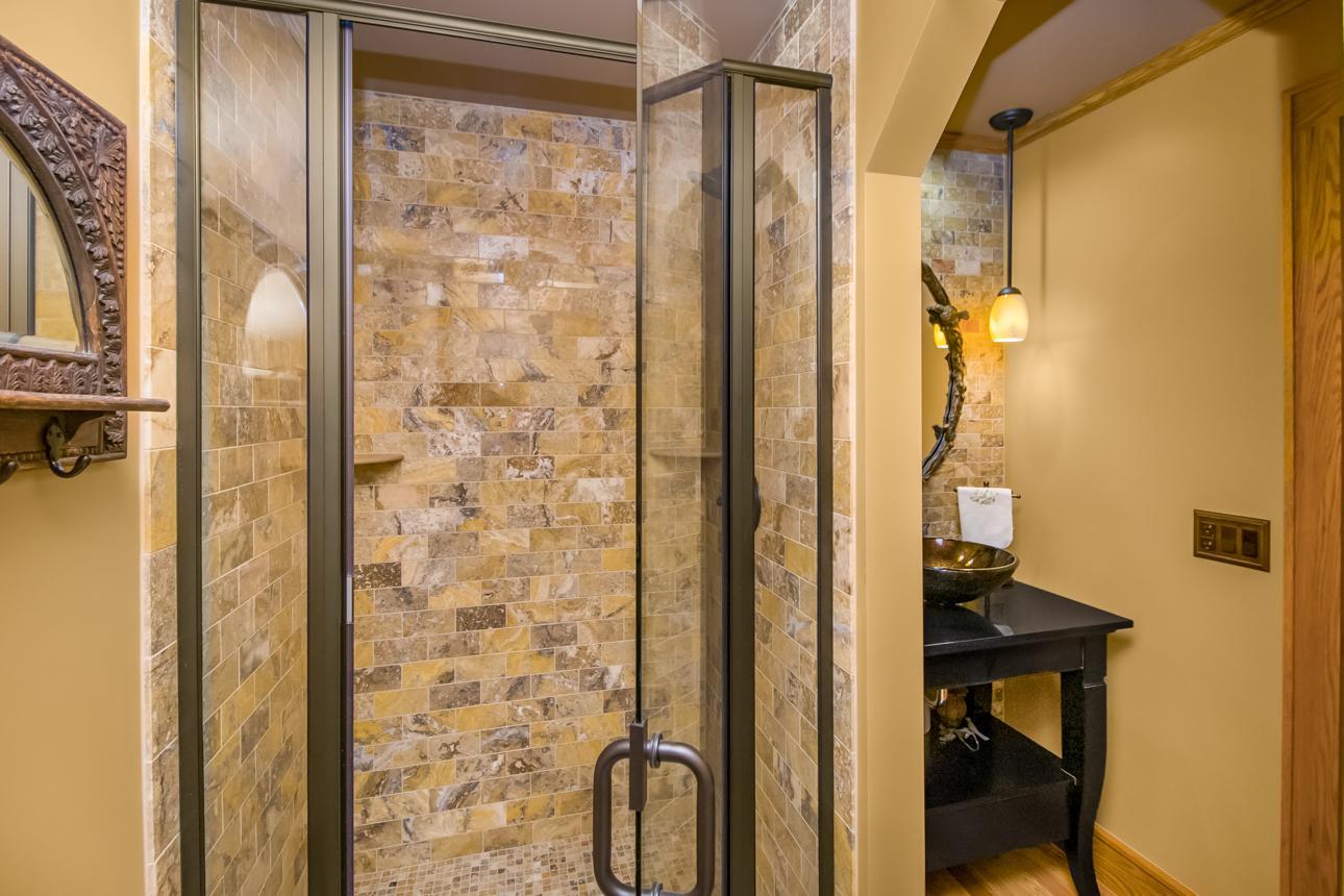 3/4 main floor guest bathroom with tiled shower and glass door