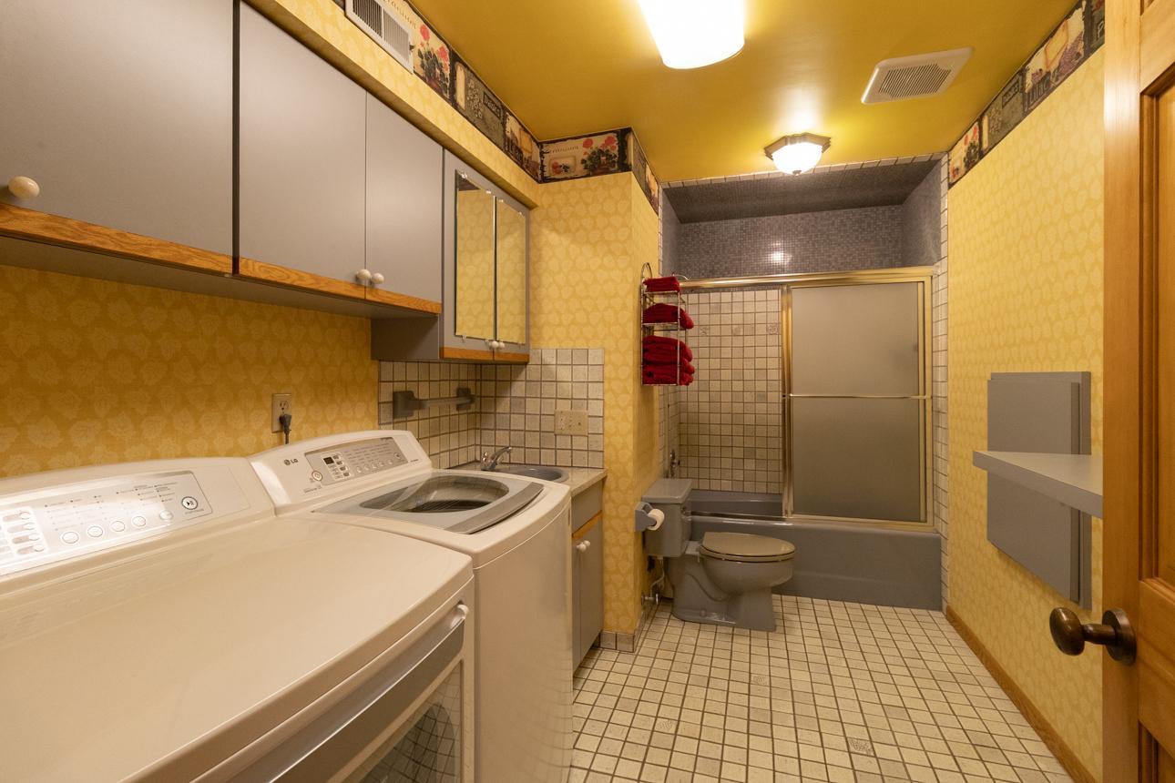Lower level full bathroom with washer/dryer and large laundry storage chute.