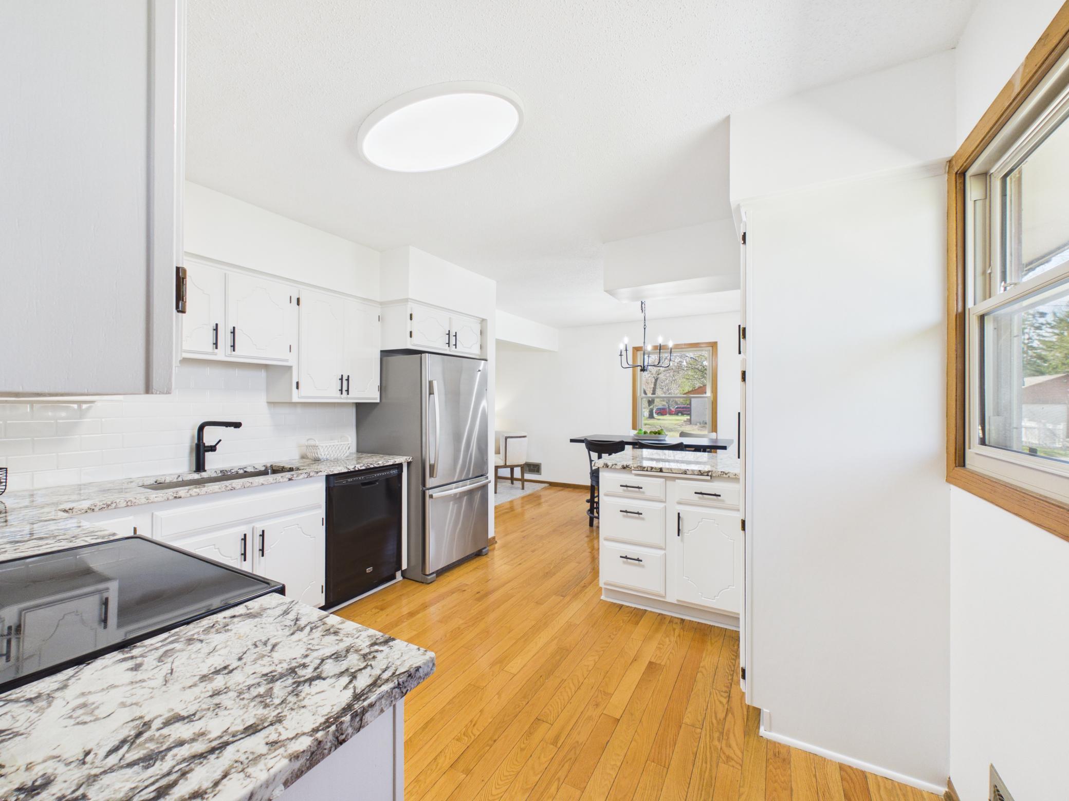 Subway tile backsplash, new granite countertops, sink and faucet modernize this once classic kitchen with lots of storage.