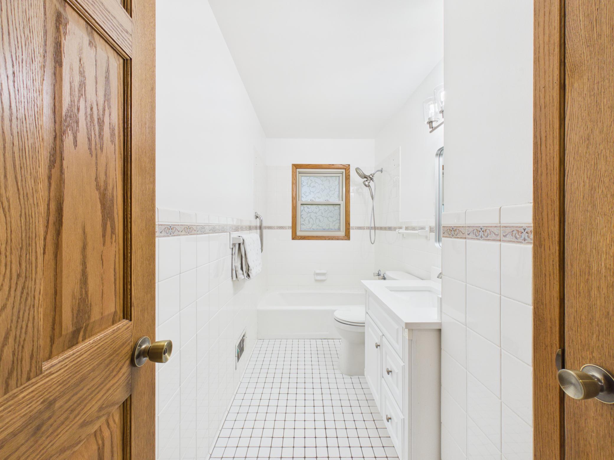 Full bath on the main floor with tile flooring and walls.