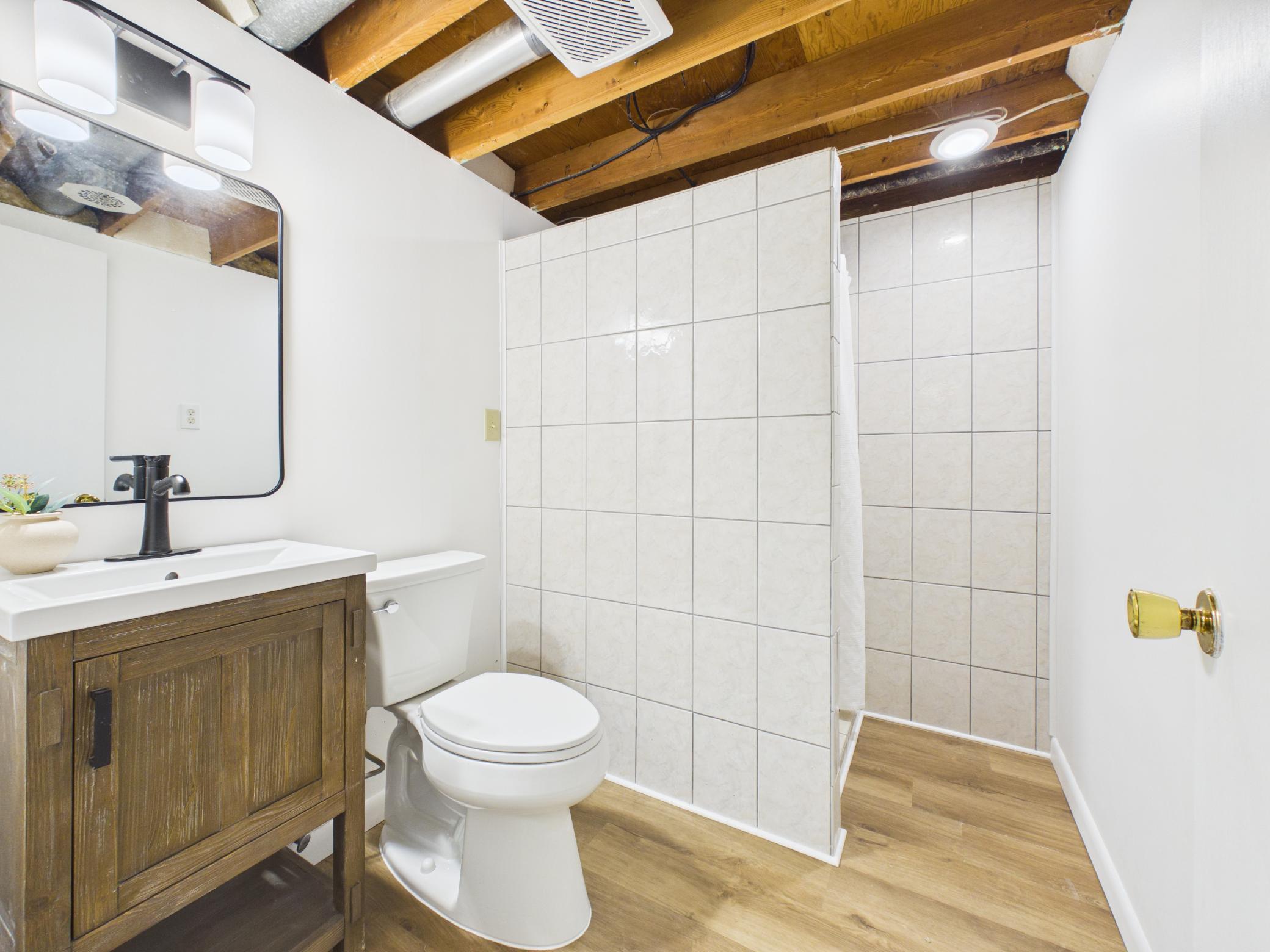 New toilet and luxury vinyl flooring make way for a step-in shower.