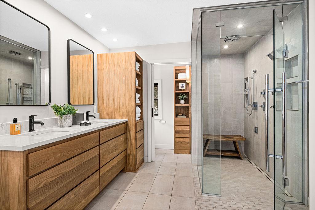 Double sinks and oversized walk-in shower complete this primary bathroom.