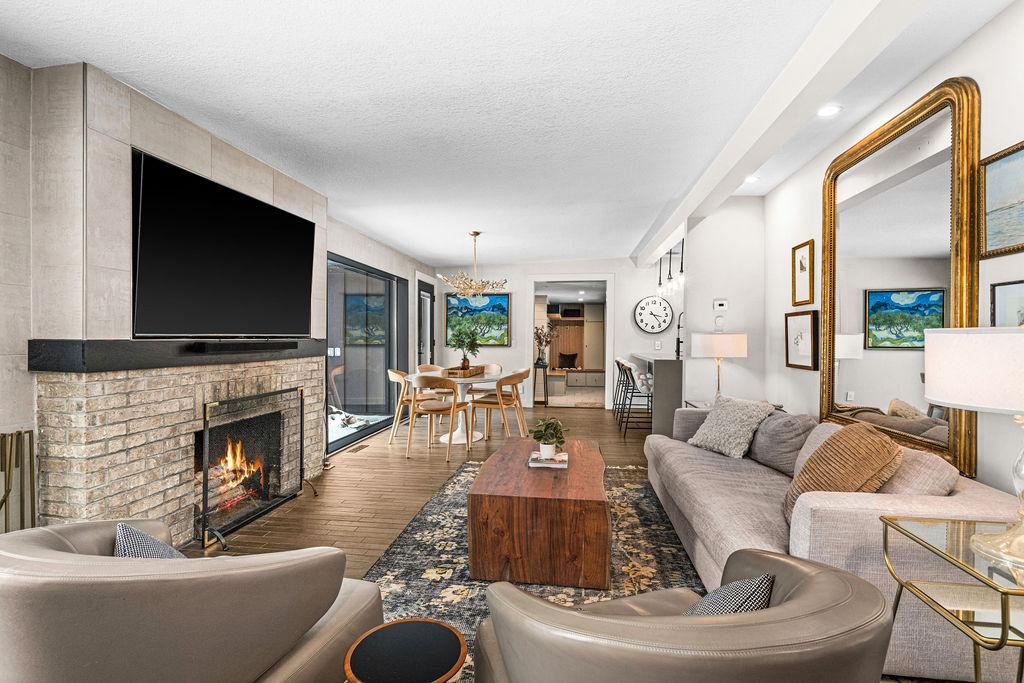A classic brick woodburning fireplace serves as a charming centerpiece in the living room featuring a new screen.