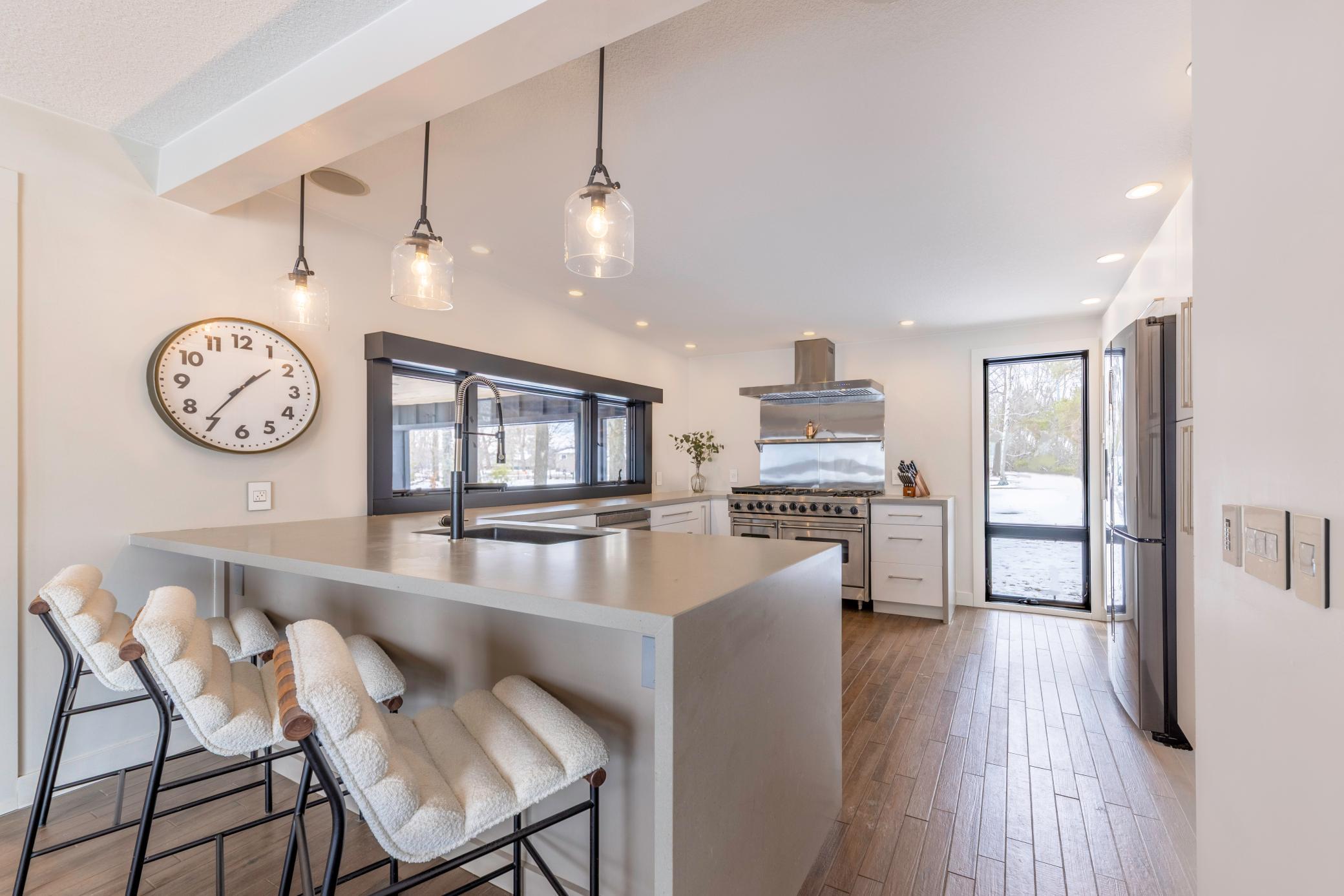 This designer kitchen boasts stunning quartz countertops with a dramatic waterfall edge.