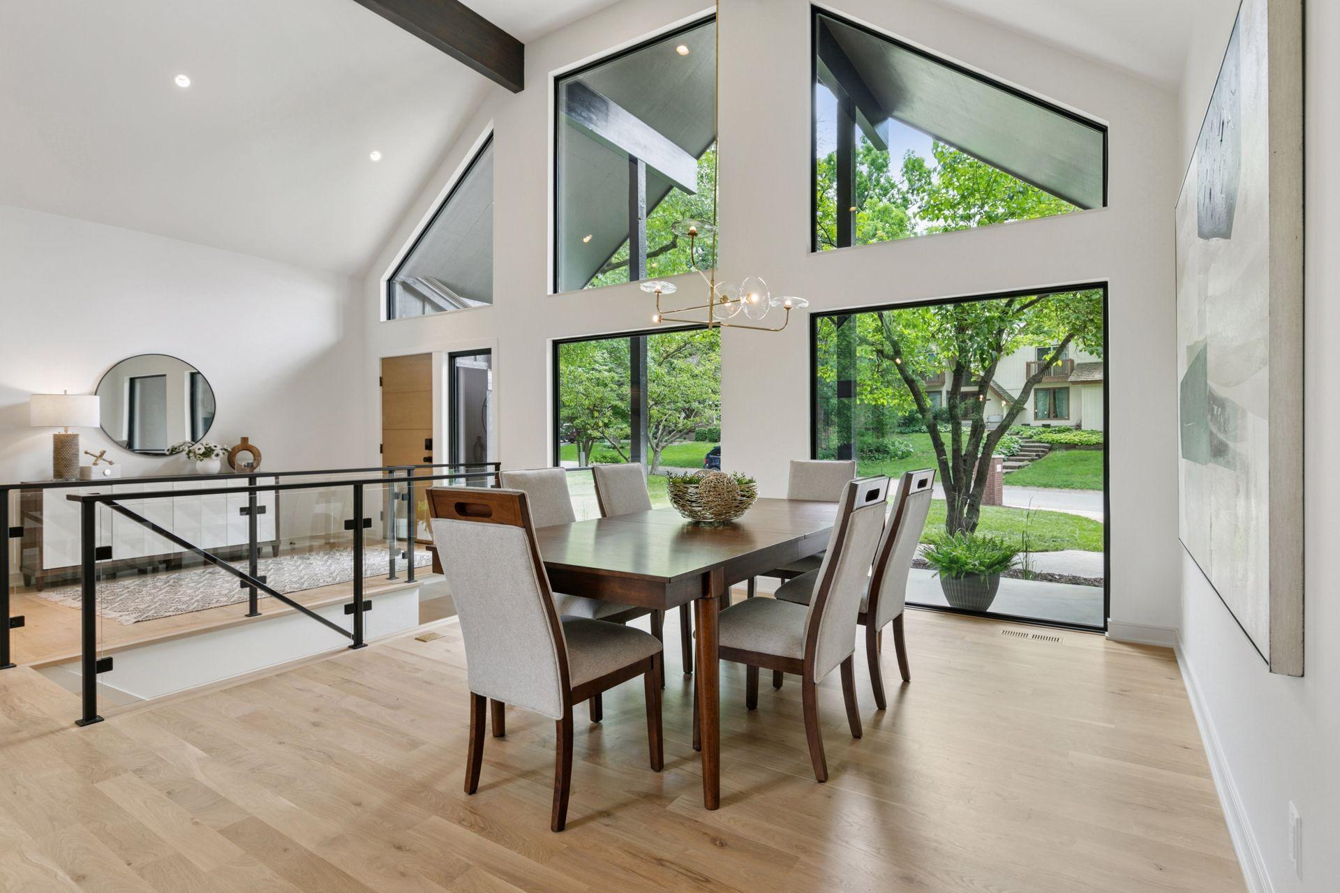 A vaulted dining space along the front of the house is framed with beautiful floor to ceiling windows.