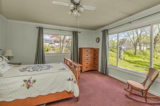 The primary main floor bedroom has large windows and a big closet