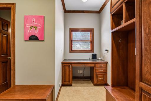 See the door to the bathroom on the left, bench with room for fun art above, 5' desk and storage lockers on the right.
