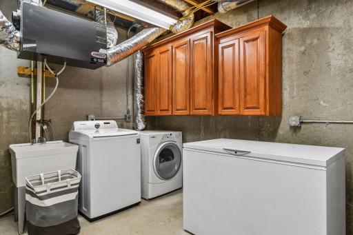 The laundry is in the basement. There is a utility sink and cupboards.