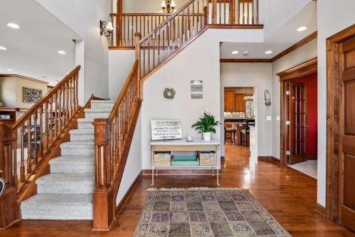 A coat closet upon entry and a substantial turned staircase that showcases the upper level greet you. The impressive real wood floors begin in the foyer and flow throughout much of this level. The dining room/office with French doors is on the right.