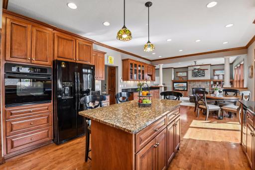 Looking out from the kitchen sink, the vast rooms are filled with rich, cherry stained maple cabinets and cherry stained REAL maple floors. Look for the many ceiling fixtures and under cabinet lights.