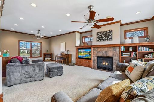 The windows are aplenty. From front to back and then east facing transoms flank the fireplace. Rich wood built-in TV space and shelving match the grand cabinets throughout the main level.