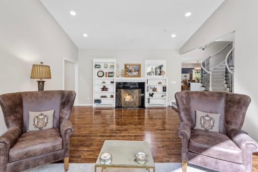 The cozy living room features a fireplace and custom-built-ins.
