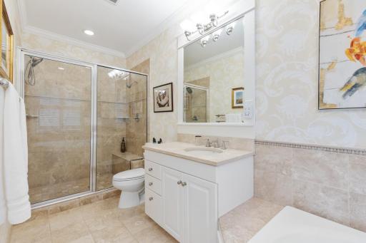 Primary suite walk-in closet featuring custom built-ins right off the ensuite bath.