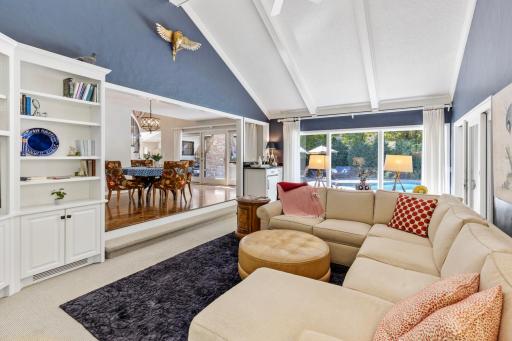 Light-filled main-level family room featuring plush carpet, large built-ins, and oversized windows.