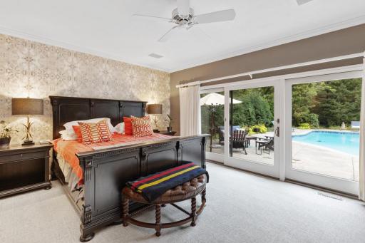 Spacious main-level primary with sliding glass doors and direct access to the patio and pool.