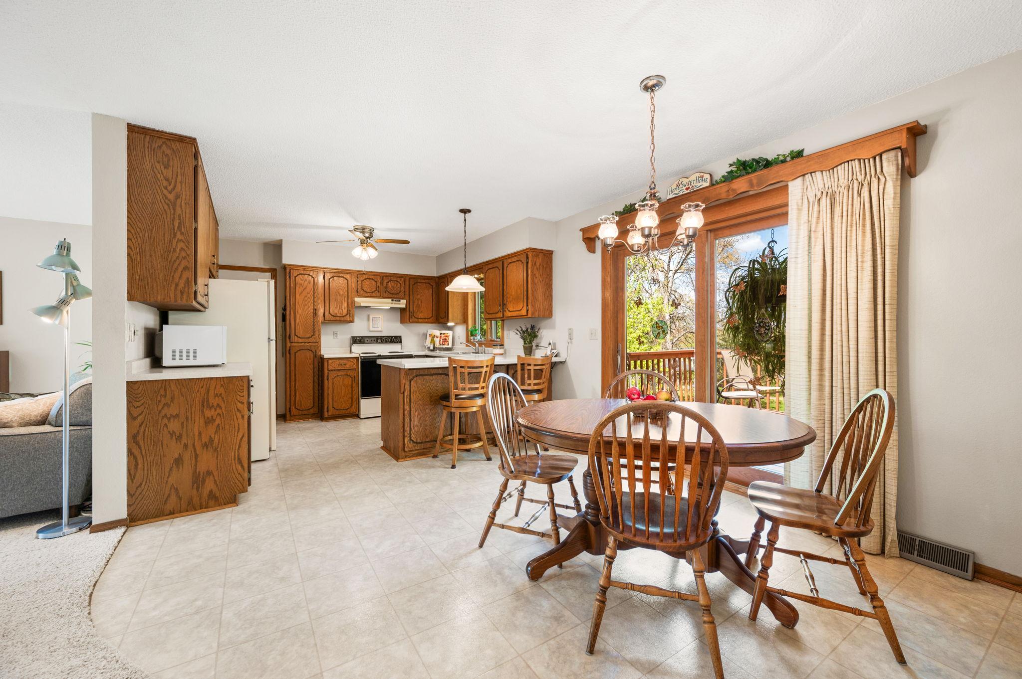 The main level features a bright kitchen with a breakfast bar that flows seamlessly into the dining and living areas