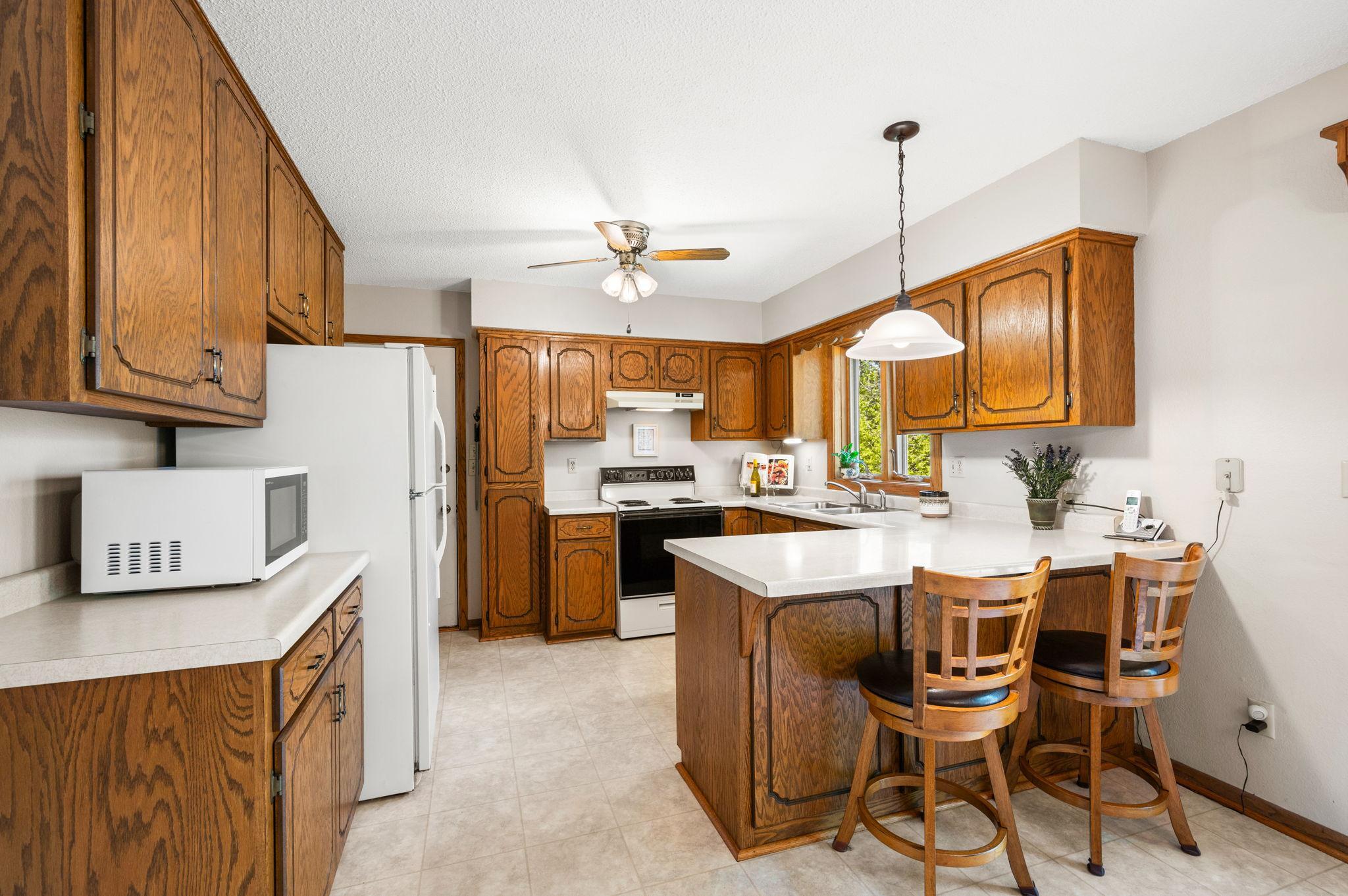 The main level features a bright kitchen with a breakfast bar that flows seamlessly into the dining and living areas