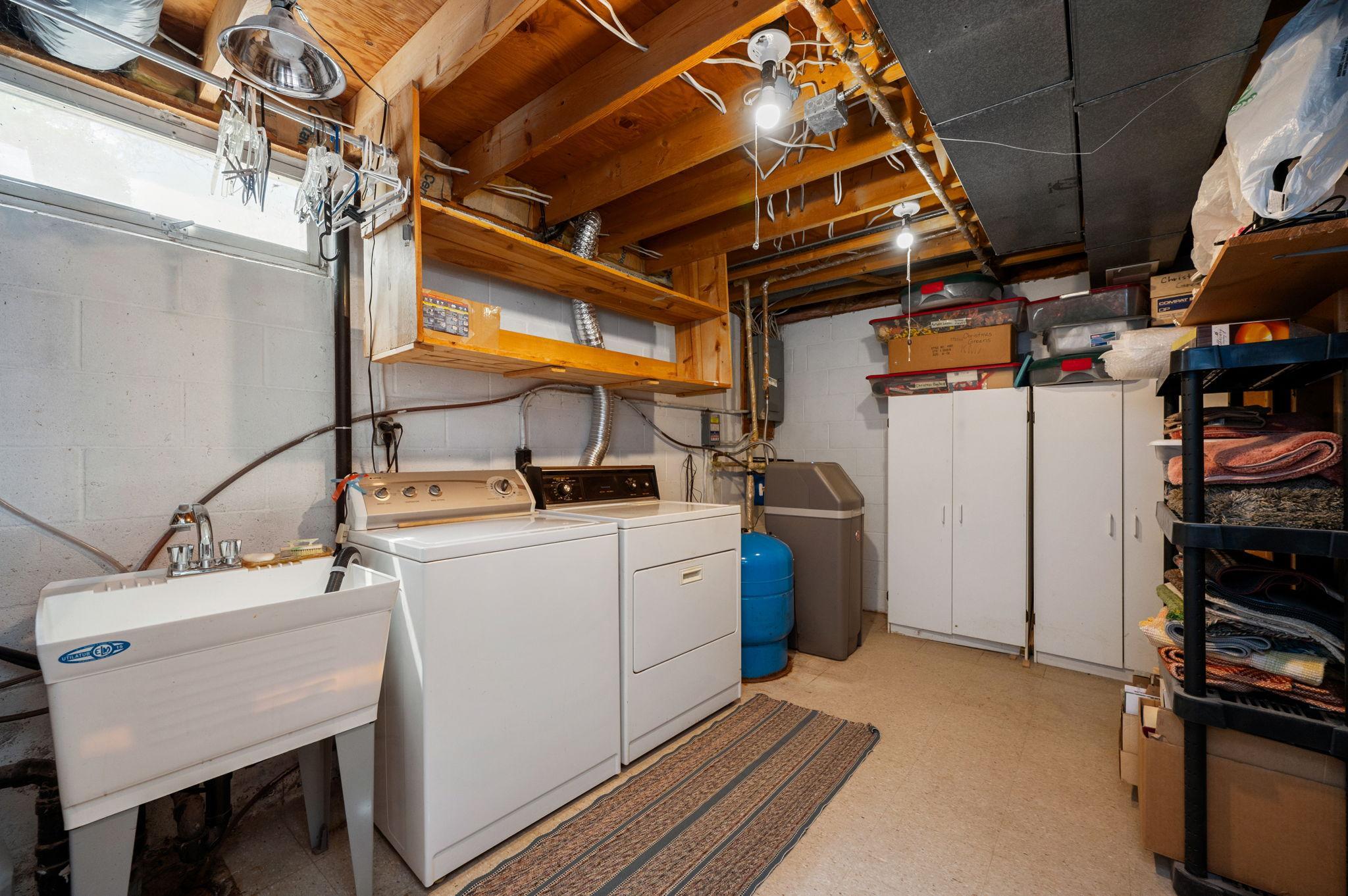 Lower level laundry room with utility sink and storage area
