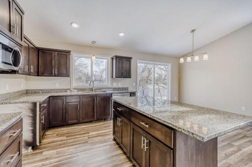 Primary home kitchen with vaulted ceilings, recessed lighting, lots of cabinets and granite countertop
