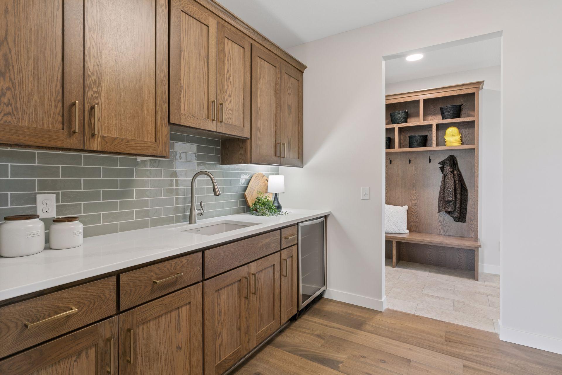 Walk-thru Butlers Pantry with an additional sink and bev fridge