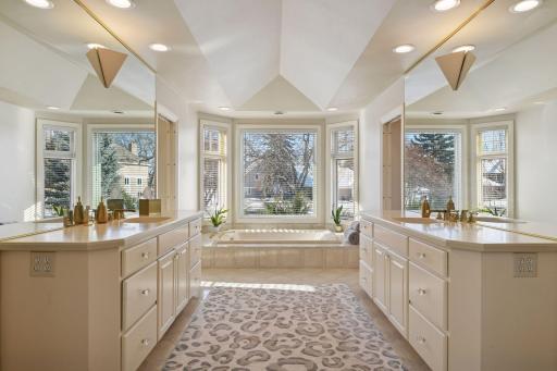 The Primary Bathroom features his and hers matching vanities and a walk-in closet behind each vanity (not shown).
