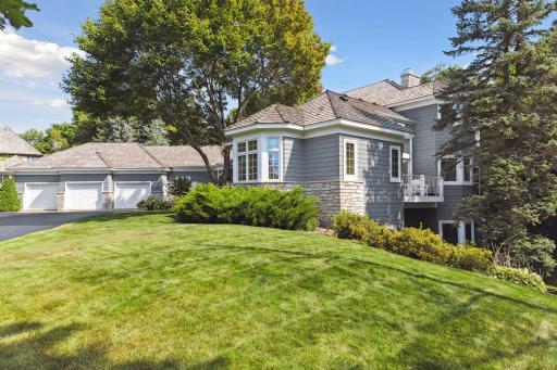 The primary bedroom suite anchors the right wing of the house and includes both the bay window and private deck shown to the right.