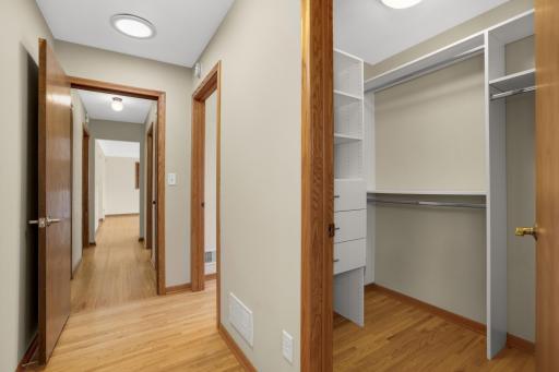 Hallway from living room with hardwood floors and a walk-in closet.