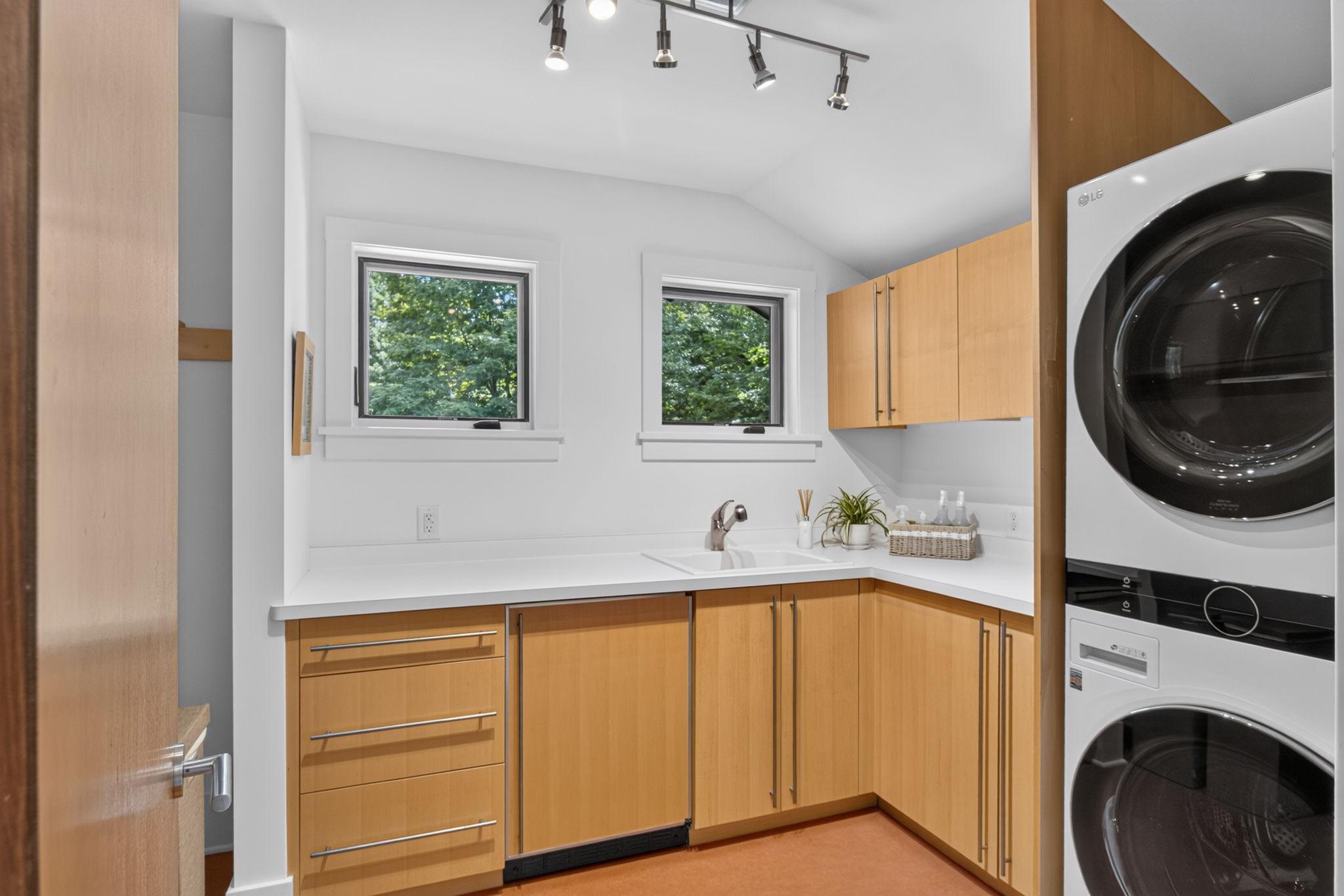 Upper level laundry room with sink and storage