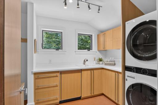 Upper level laundry room with sink and storage