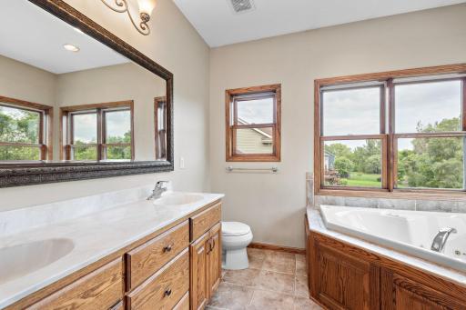 Primary/Owners bathroom with River Views, double vanity, separate jetted tub and shower and tile surround!