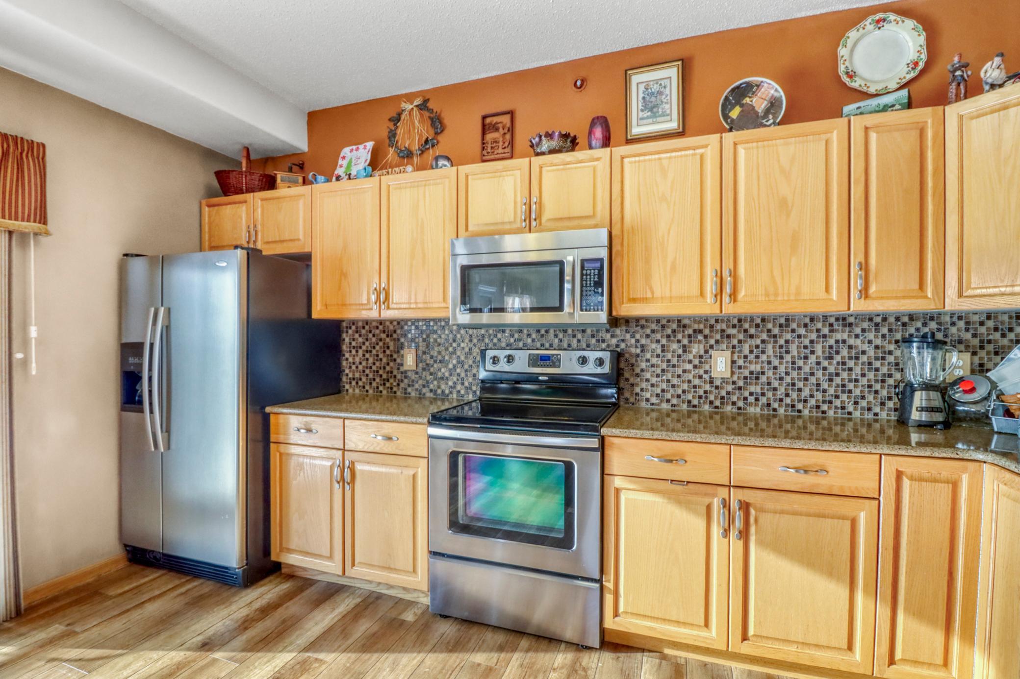 Kitchen features quartz countertops and tile backsplash