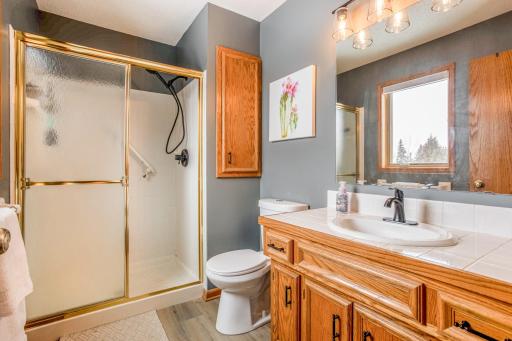Well-appointed bathroom featuring a large vanity, ample storage, and a walk-in shower with glass enclosure.