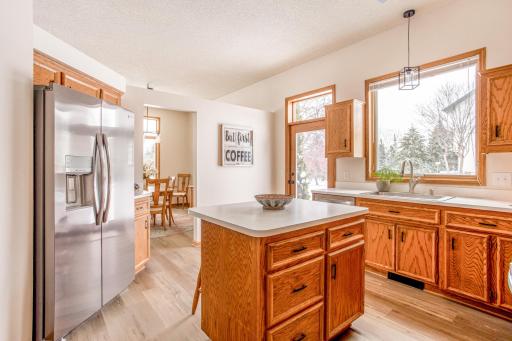 Spacious kitchen with stainless steel appliances, abundant cabinetry, and large windows that fill the space with natural light while offering views of the backyard.