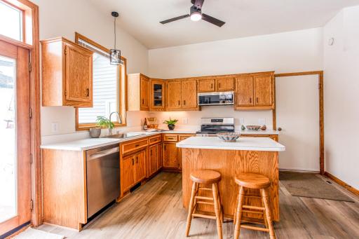 Warm and inviting kitchen featuring abundant cabinetry, a center island with seating, and an open layout ideal for everyday living.