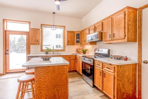 Bright and welcoming kitchen featuring warm wood cabinetry, ample counter space, and a convenient center island with seatingâperfect for casual dining or entertaining.