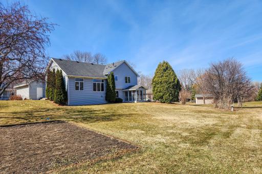 Expansive backyard offering plenty of open space for outdoor activities, highlighted by a screened porch ideal for relaxing and enjoying the surroundings.