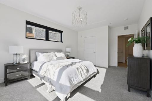 This primary suite offers a spacious walk-in closet and an en-suite full bathroom.