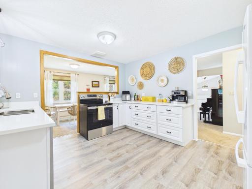 Brand new and ready to cook! Freshly remodeled kitchen featuring new white cabinetry, quartz countertops, new flooring, and stainless steel appliances. Bright, modern, and open to the dining area. A kitchen you'll actually want to spend time in!