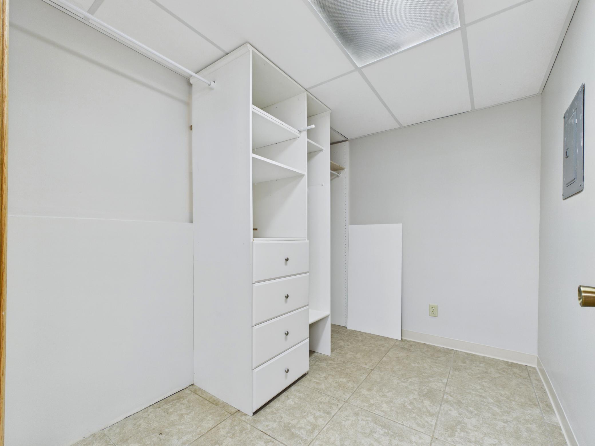 Built-in closet with shelving and drawers offers excellent storage or wardrobe space.