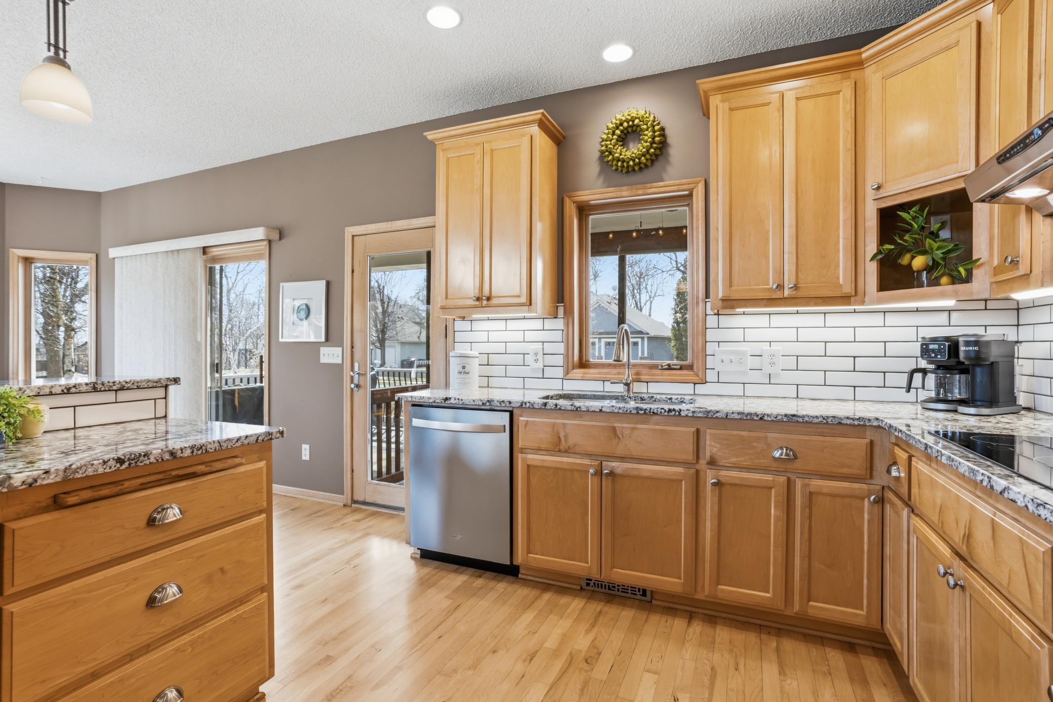 The kitchen window overlooks the charming screened porch, bringing in natural light and a view of the inviting outdoor space.