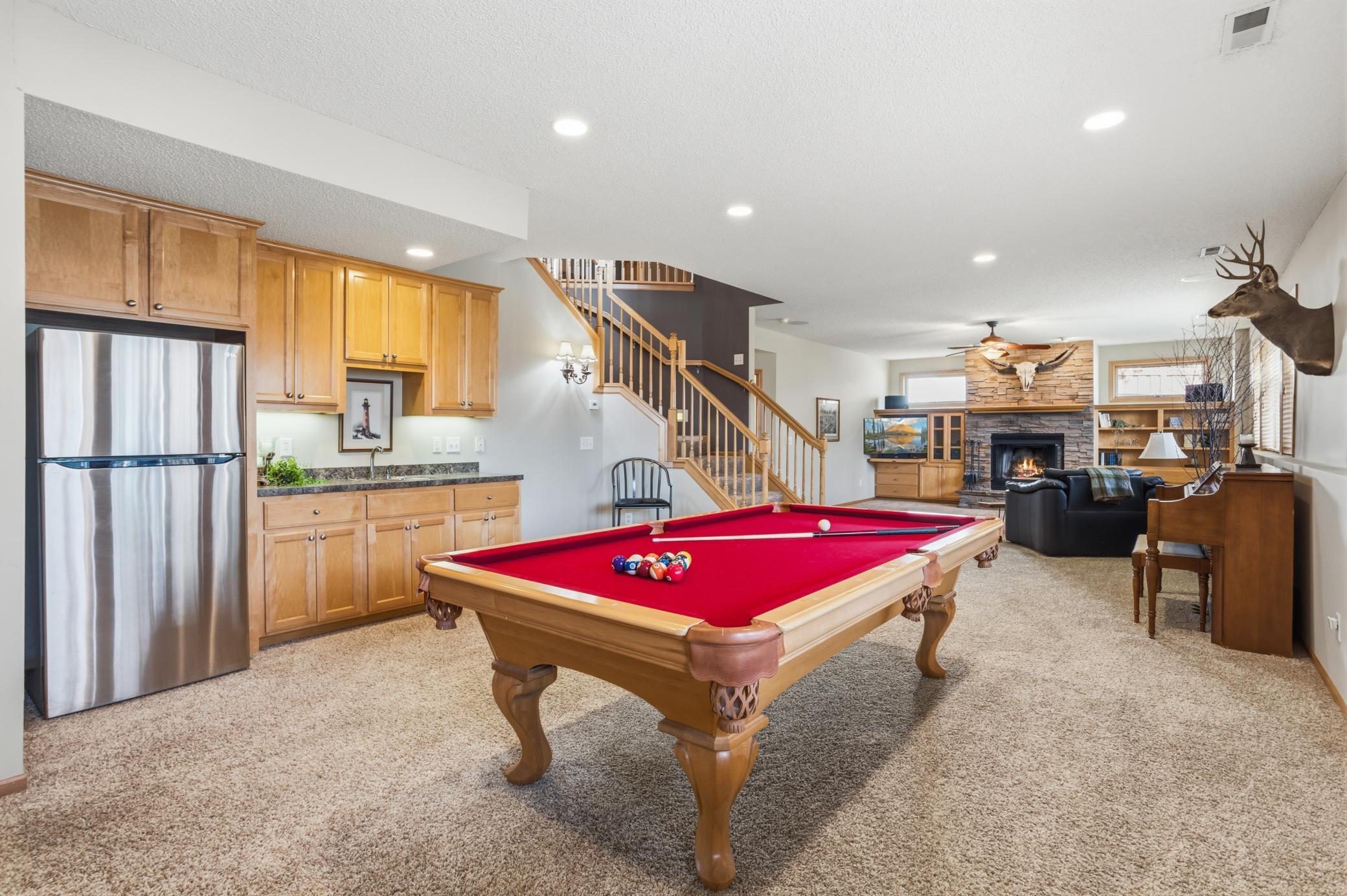 Billiards room is flanked by a wet bar on one side and windows on the other.