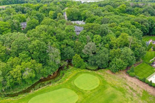 A serene, tree-lined Jack Nicklausâdesigned golf course nestled within a gated luxury community.
