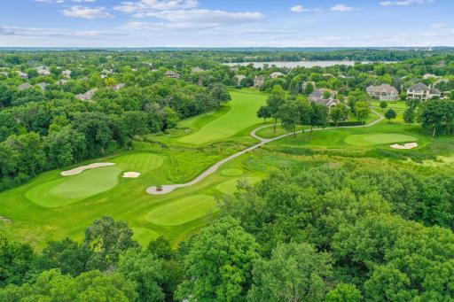 A serene, tree-lined Jack Nicklausâdesigned golf course nestled within a gated luxury community.