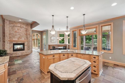 20The gourmet kitchen shines with granite counters, slate flooring, a hearth room, and a large breakfast bar that opens to the informal dining area and screen porch.