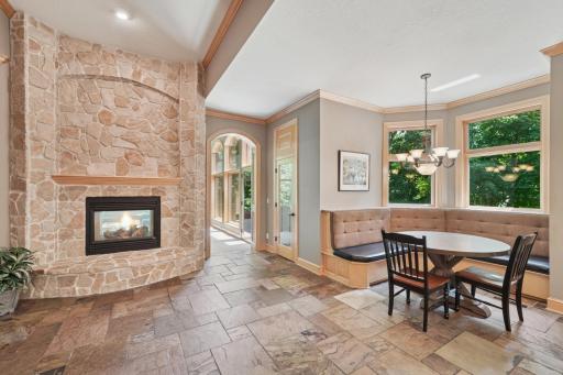 The gourmet kitchen shines with granite counters, slate flooring, a hearth room, and a large breakfast bar that opens to the informal dining area and screen porch.
