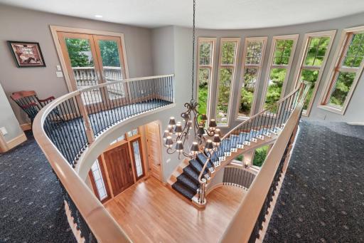 Dramatic two-story foyer with curved staircase centerpiece.