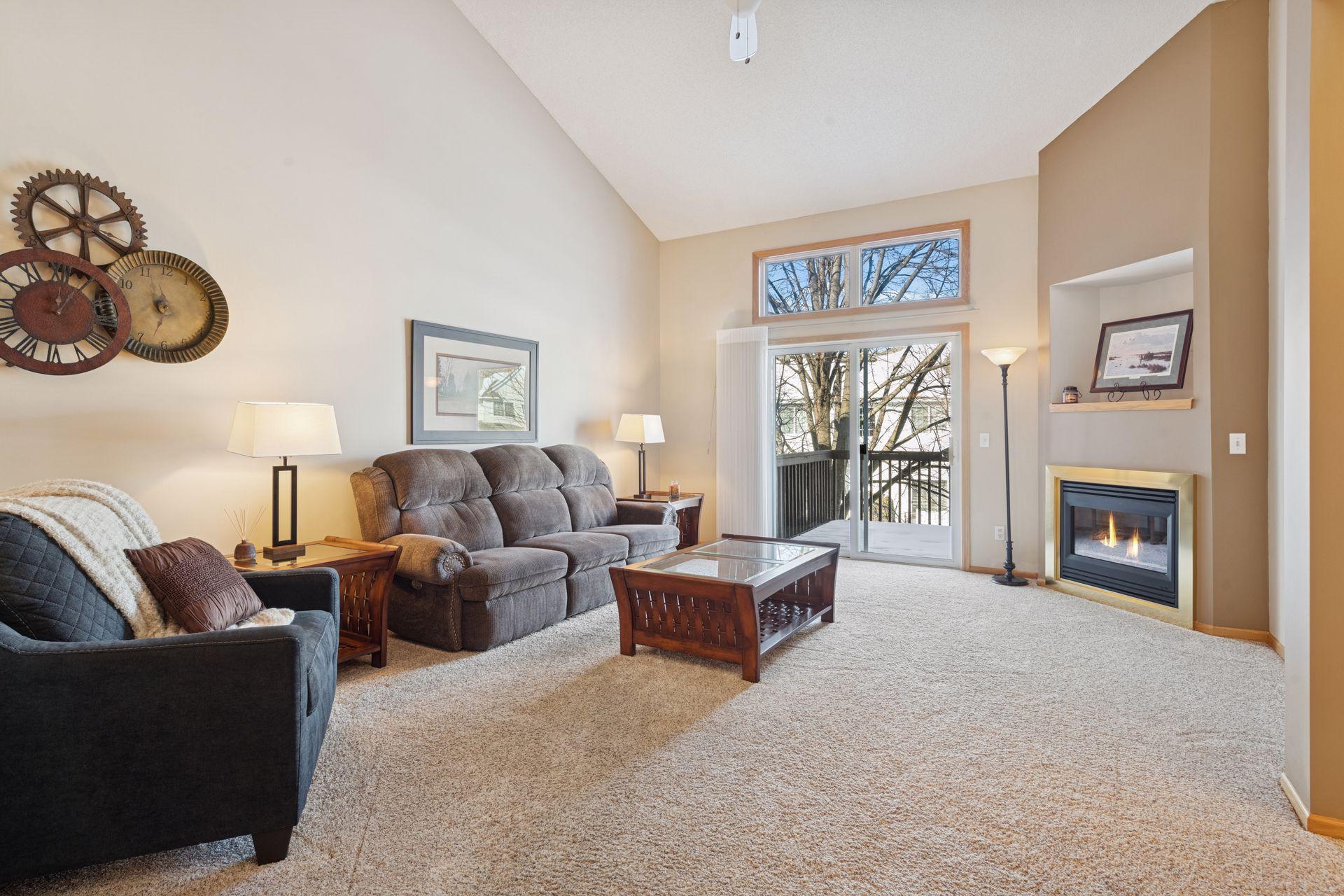 Sunny, vaulted living room with backyard views and cozy gas fireplace