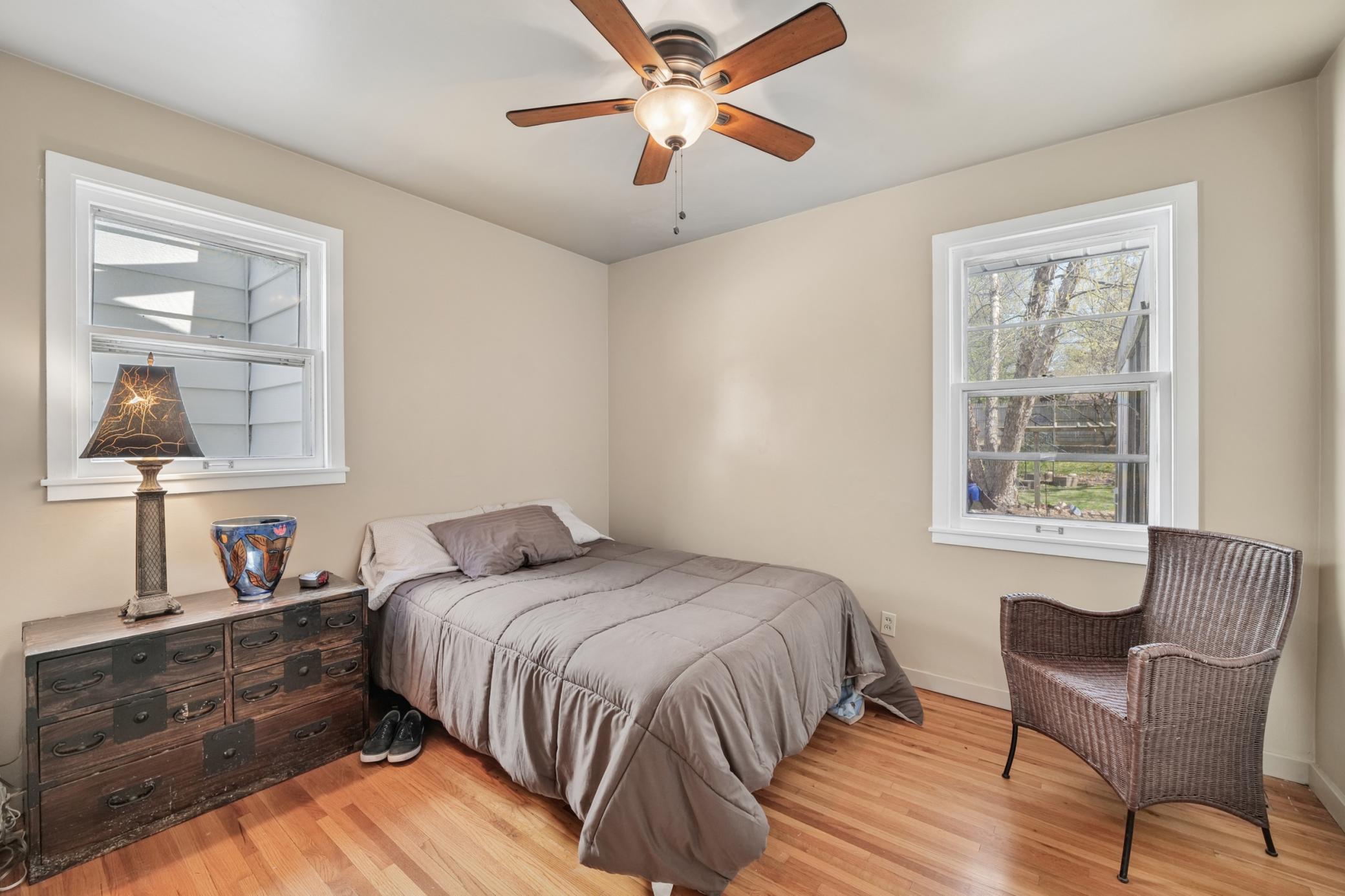 Primary Bedroom with two windows, hardwood floors, closet and ceiling fan. Bright and cheery in the morning to start your happy day. Relaxing retreat in the evening for downtime, reading a great book and a goodnight sleep.