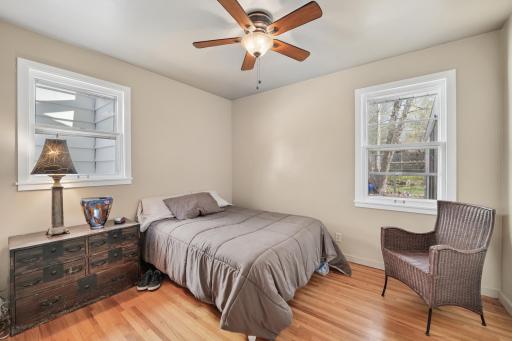 Primary Bedroom with two windows, hardwood floors, closet and ceiling fan. Bright and cheery in the morning to start your happy day. Relaxing retreat in the evening for downtime, reading a great book and a goodnight sleep.
