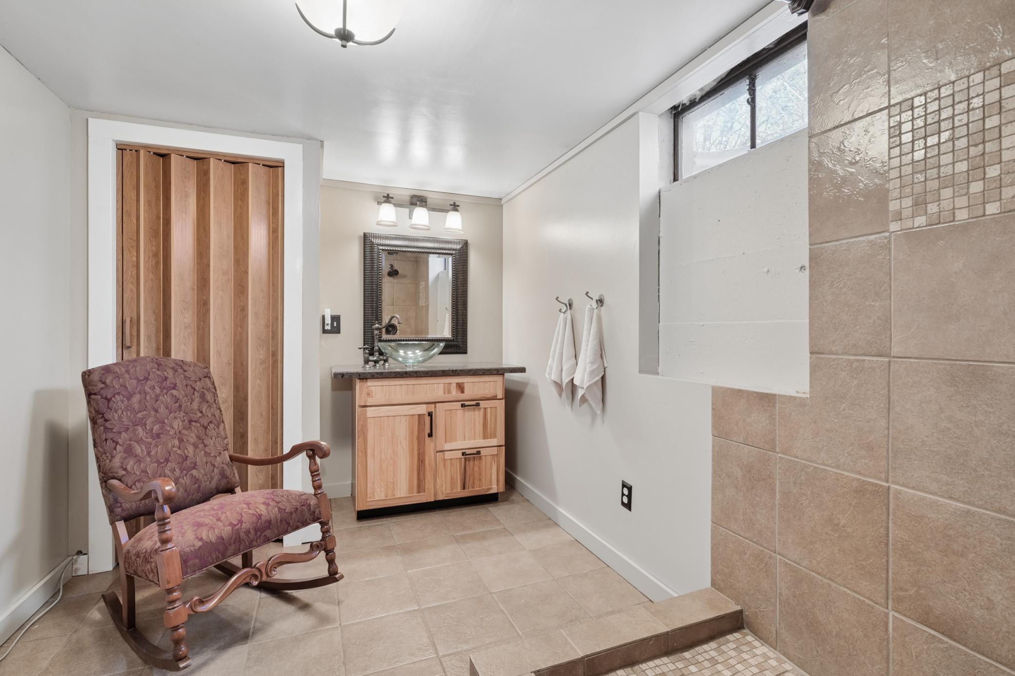 Bathroom 2 in the lower level has a shower and vanity with sink, drying hooks for the towels and clothes.